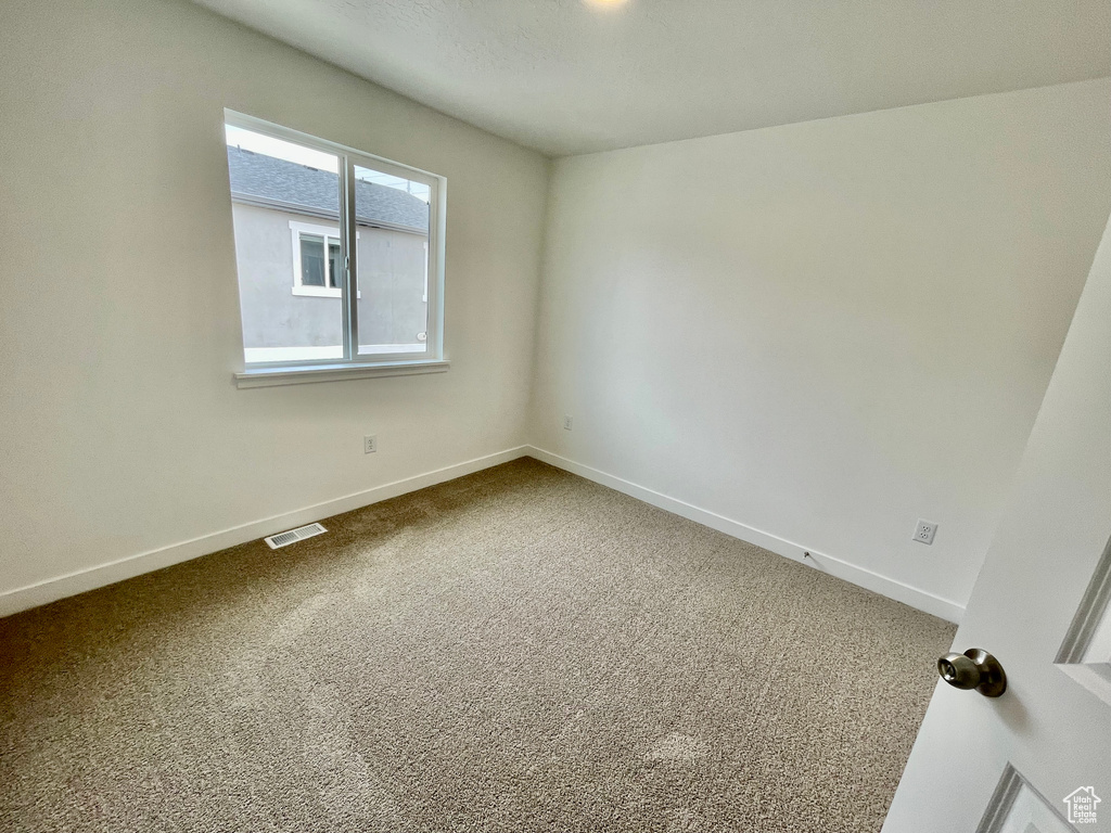 Unfurnished room featuring visible vents, baseboards, and carpet floors