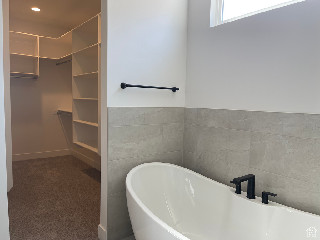 Bathroom featuring a spacious closet and a freestanding bath