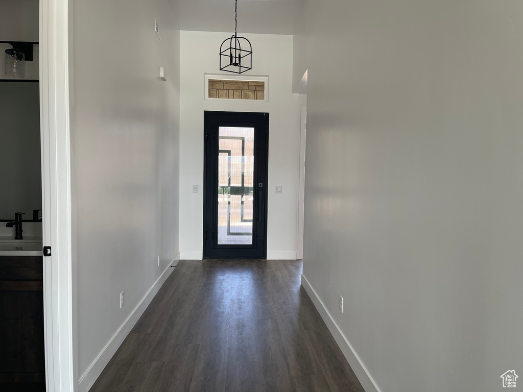 Doorway to outside featuring dark wood-type flooring, baseboards, and a sink