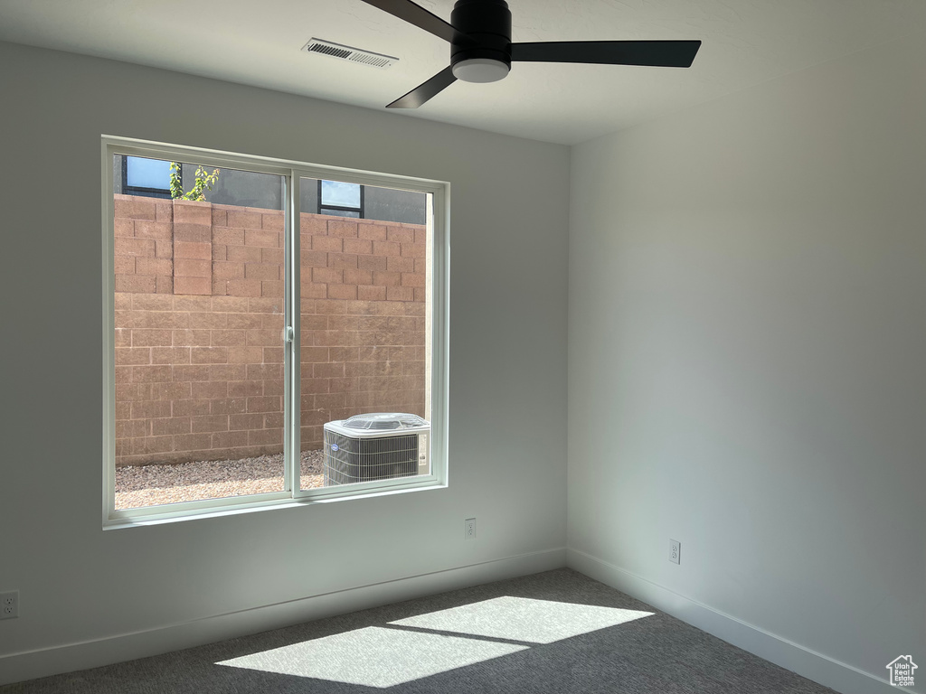 Spare room with a ceiling fan, carpet floors, and baseboards