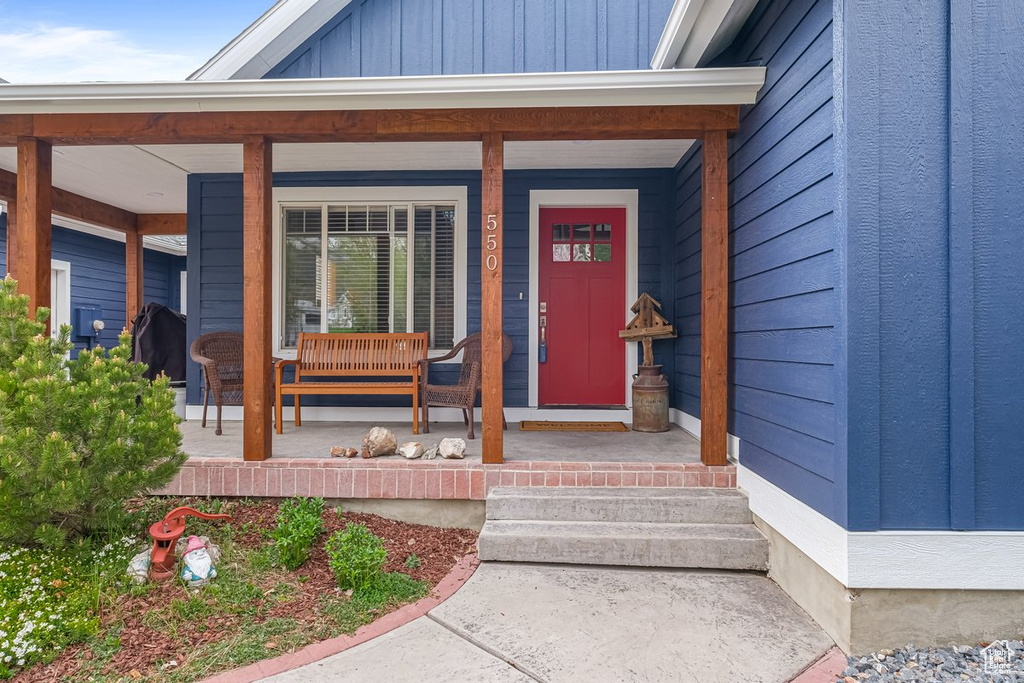 Entrance to property with board and batten siding and a porch