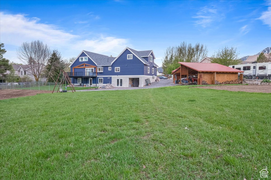 Back of house with fence and a yard
