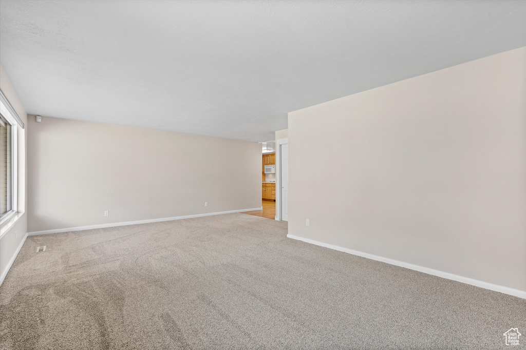 Carpeted empty room featuring baseboards