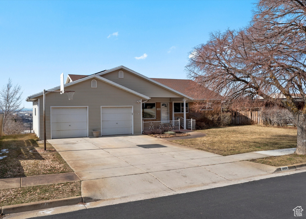 Ranch-style house with a porch, a front yard, driveway, and an attached garage