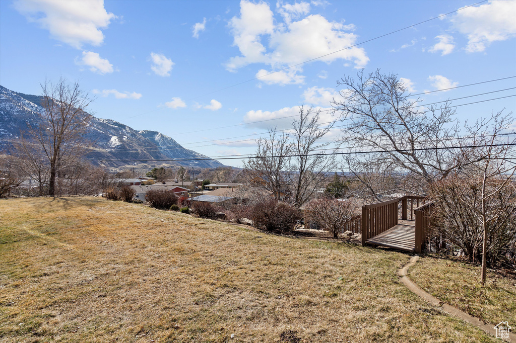 View of yard with a deck with mountain view