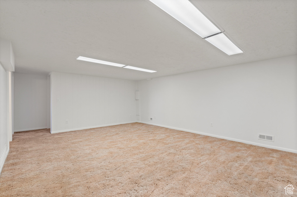 Carpeted empty room with visible vents and baseboards