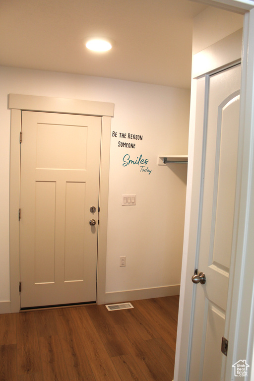 Doorway with dark wood-style flooring, baseboards, and recessed lighting