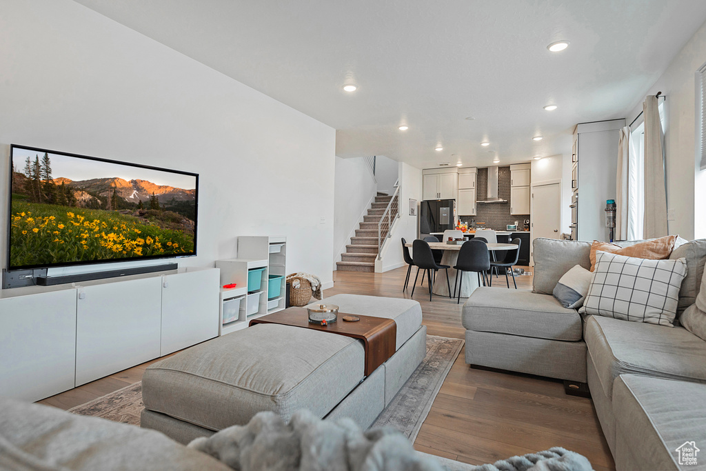 Living area with stairway, wood finished floors, and recessed lighting