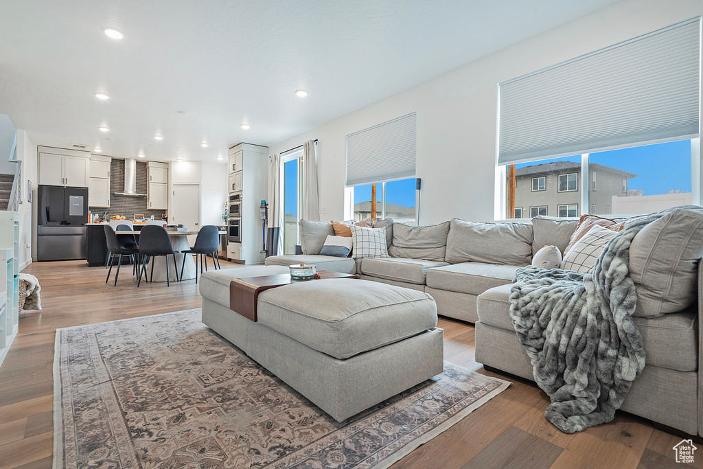 Living room with light wood finished floors and recessed lighting