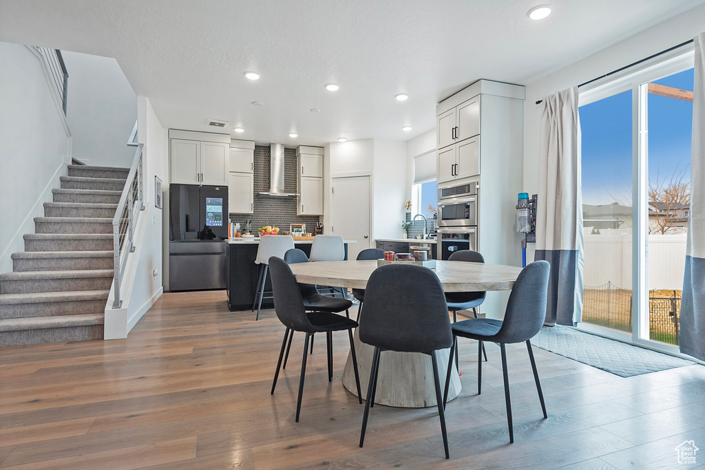 Dining space featuring recessed lighting, stairway, baseboards, and wood finished floors