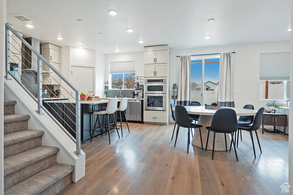 Dining room featuring light wood-type flooring, stairs, and recessed lighting