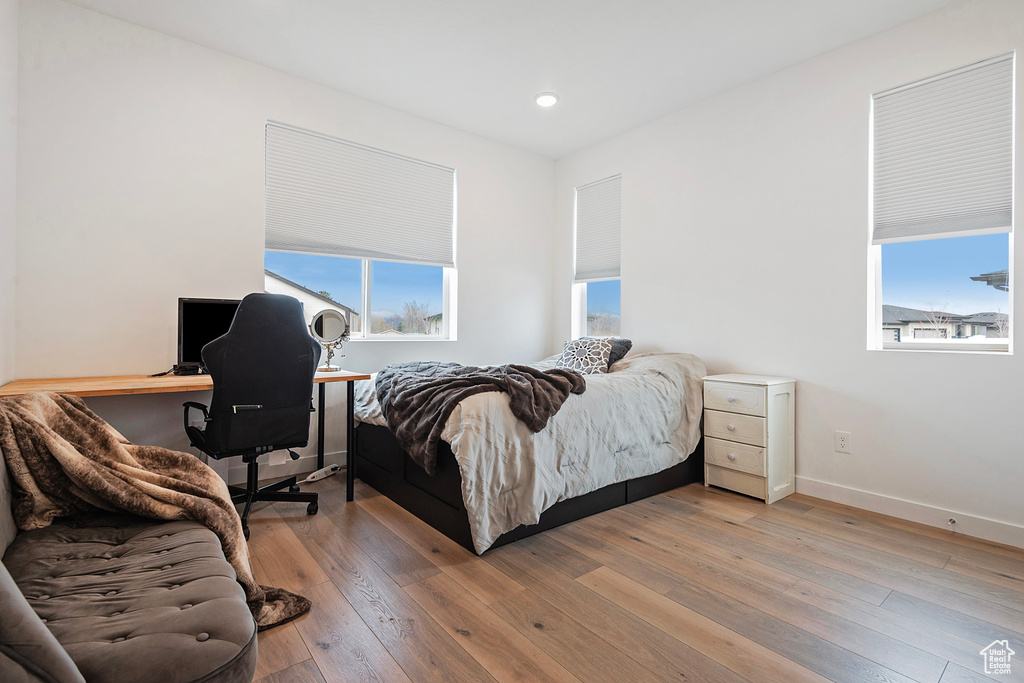 Bedroom with recessed lighting, multiple windows, light wood-type flooring, and baseboards