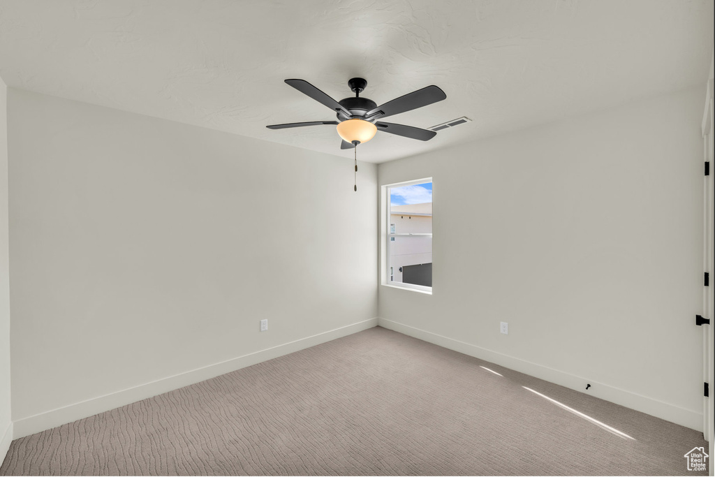 Unfurnished room with light carpet, ceiling fan, visible vents, and baseboards