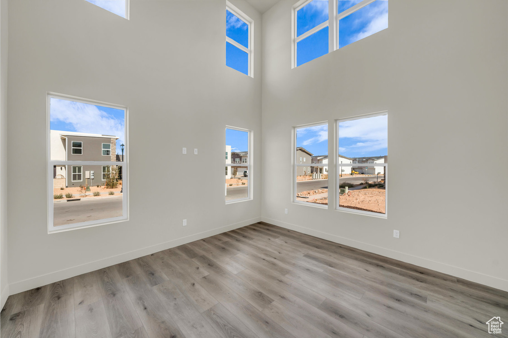 Interior space with a high ceiling, baseboards, and wood finished floors