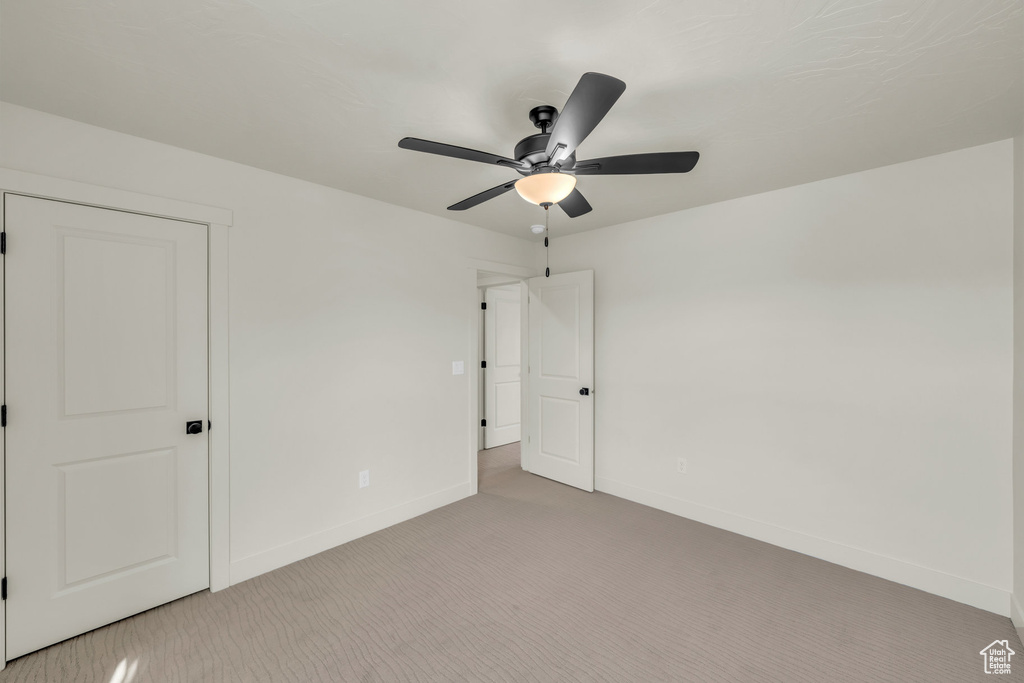 Unfurnished bedroom with ceiling fan, carpet, and baseboards