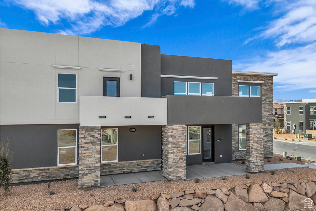 View of front facade featuring stone siding and stucco siding