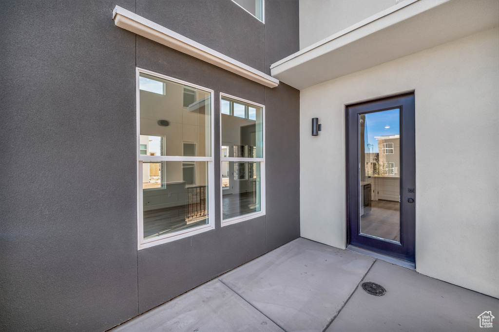 Entrance to property with a patio area and stucco siding