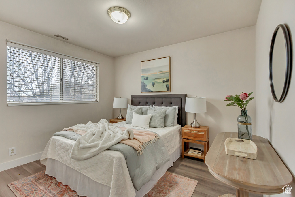 Bedroom with visible vents, baseboards, and wood finished floors