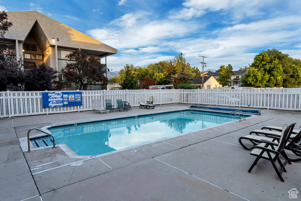 Community pool with a patio area and fence