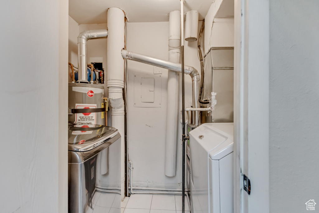 Clothes washing area featuring washer / dryer, laundry area, secured water heater, and light tile patterned floors