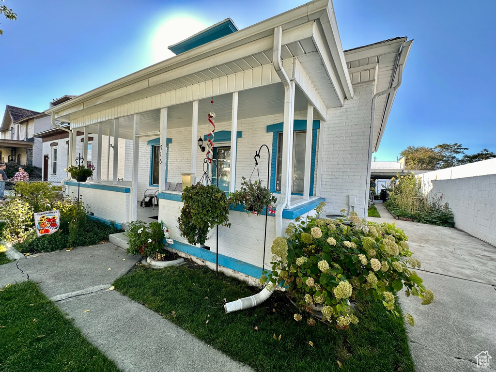 View of front of house featuring fence, a porch, and brick siding