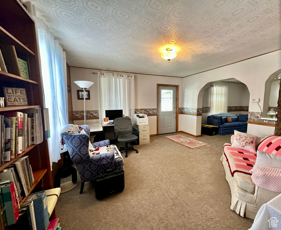 Carpeted home office with arched walkways and wainscoting