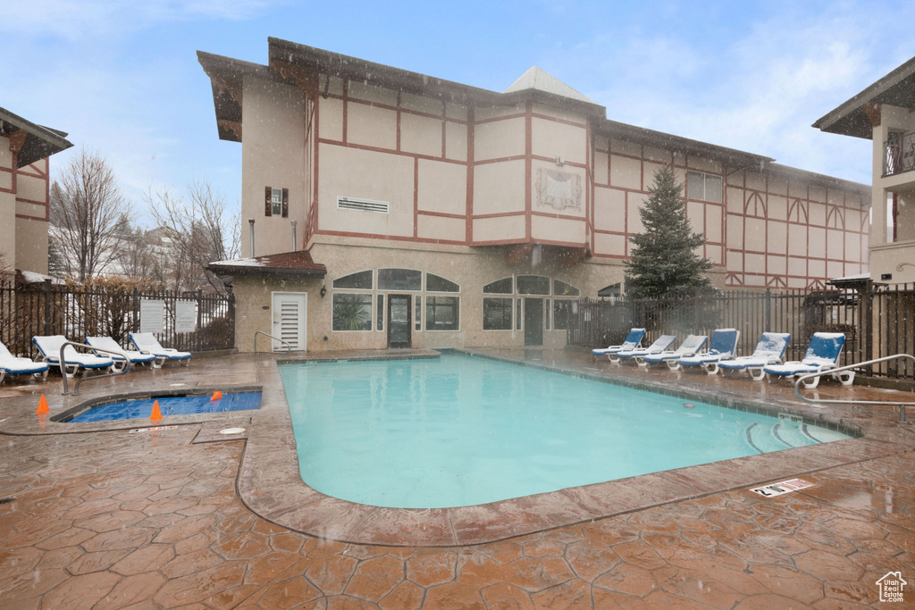 Community pool with a patio and fence