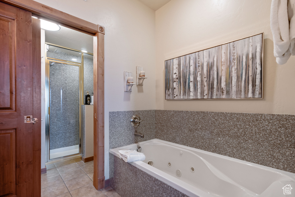 Bathroom featuring a shower stall, a whirlpool tub, and tile patterned floors