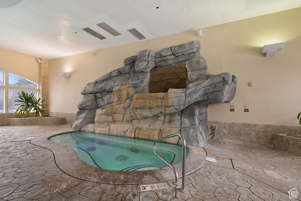 View of swimming pool featuring a patio area and an indoor hot tub