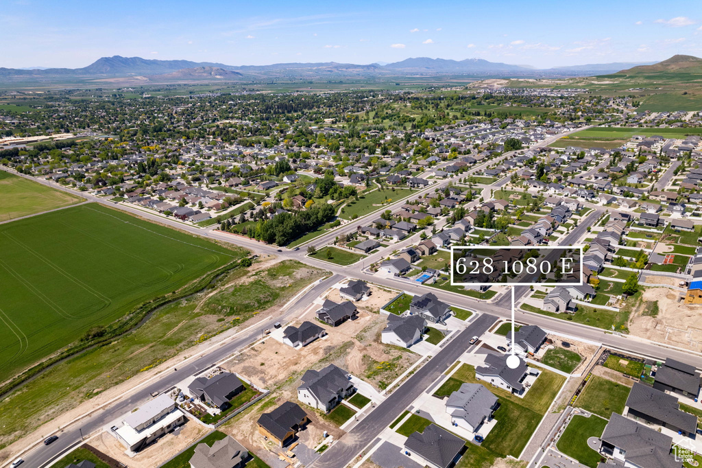 Aerial view of property's location with a mountain backdrop and nearby suburban area