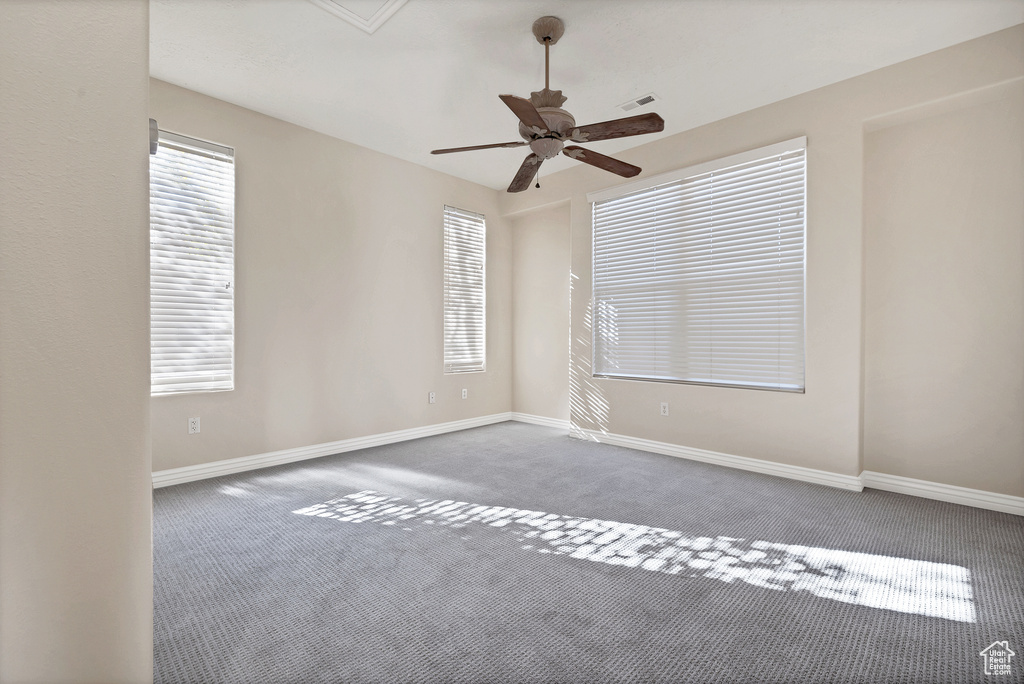 Spare room with carpet floors, visible vents, and baseboards