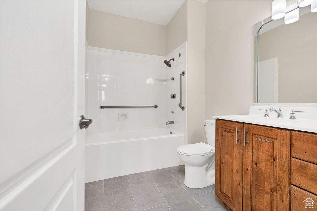 Bathroom with washtub / shower combination, vanity, tile patterned flooring, and toilet