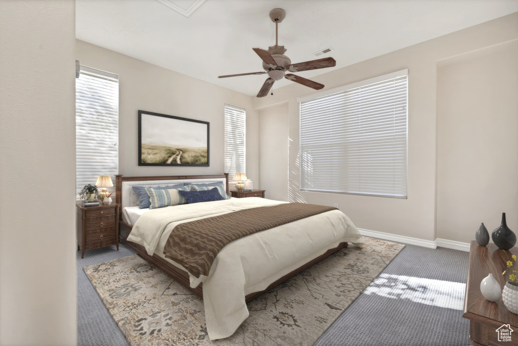 Carpeted bedroom with ceiling fan, visible vents, and baseboards