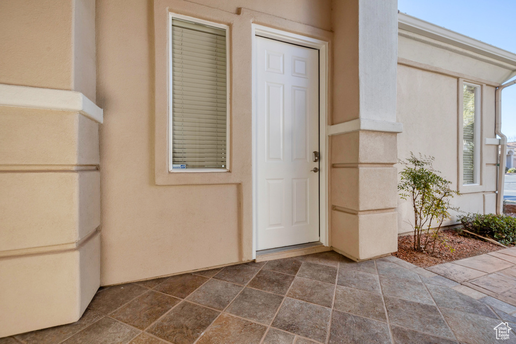 Property entrance with a patio area and stucco siding