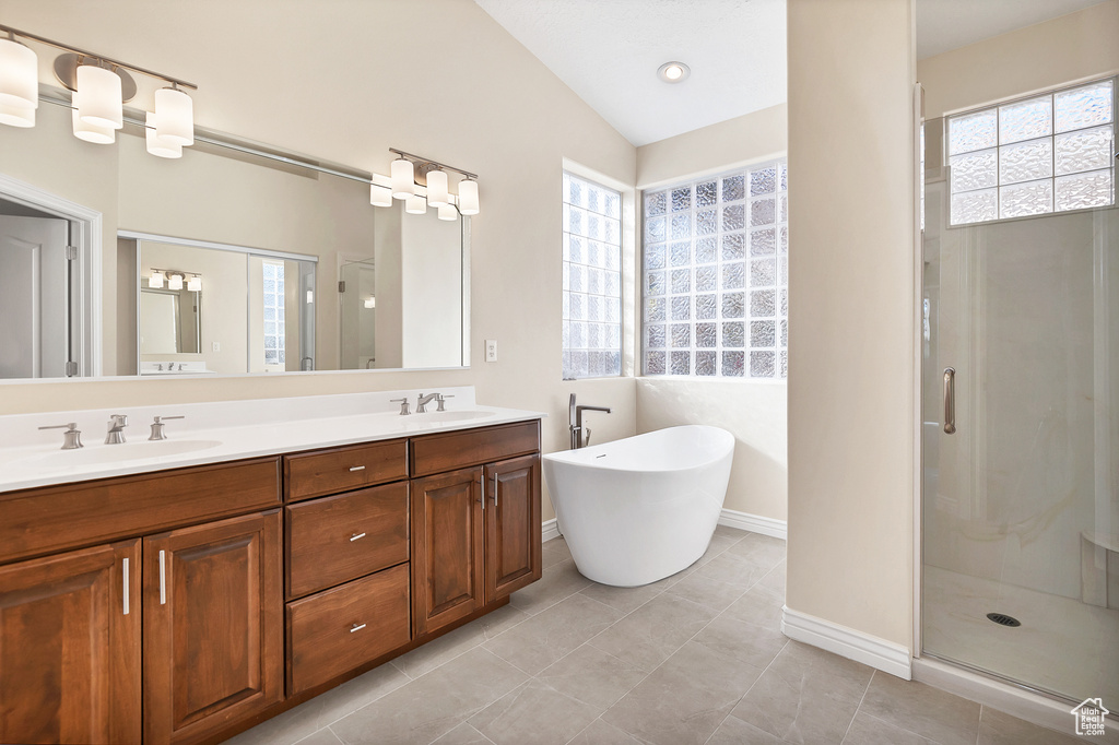 Full bath with double vanity, a stall shower, a soaking tub, and a sink