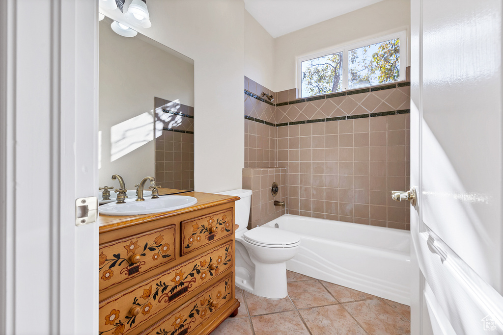 Bathroom featuring  shower combination, vanity, toilet, and tile patterned floors