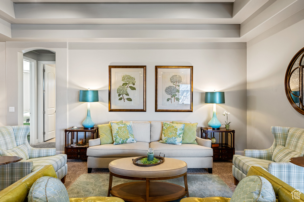 Carpeted living room with arched walkways