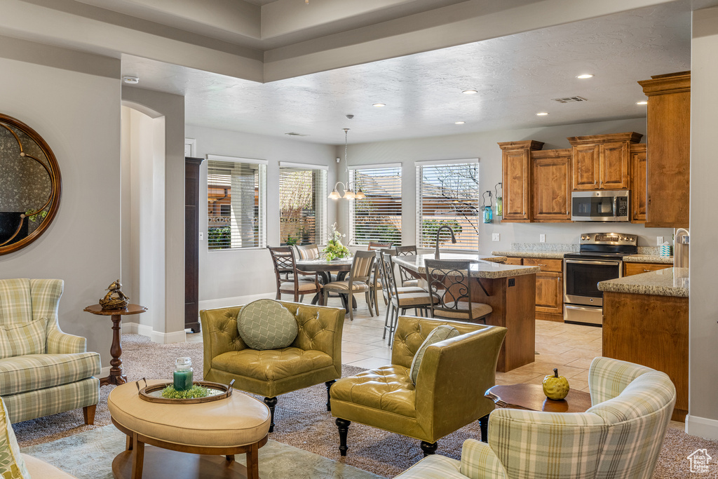 Living area with light tile patterned floors, an inviting chandelier, visible vents, and recessed lighting