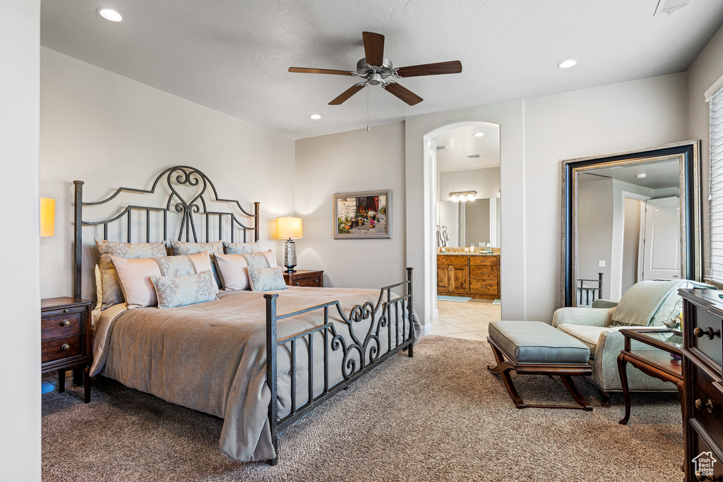 Carpeted bedroom featuring ensuite bath, arched walkways, a ceiling fan, and recessed lighting