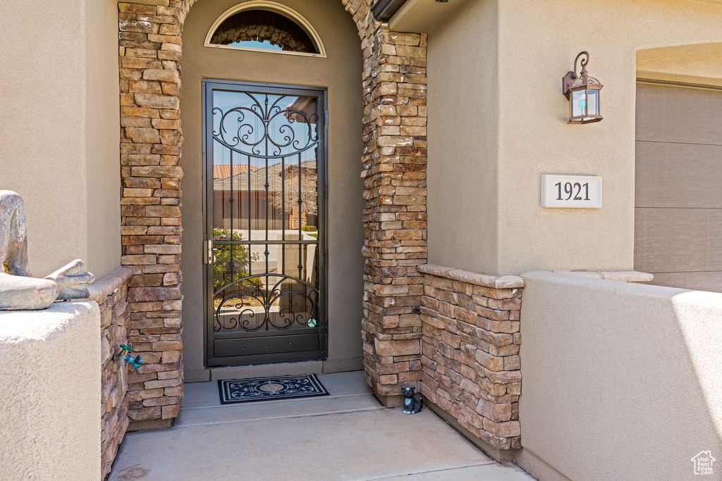 Entrance to property featuring stone siding and stucco siding