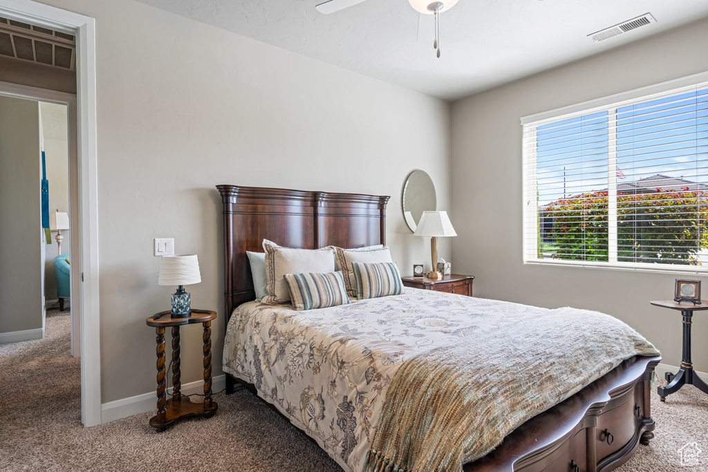 Carpeted bedroom featuring visible vents, ceiling fan, and baseboards