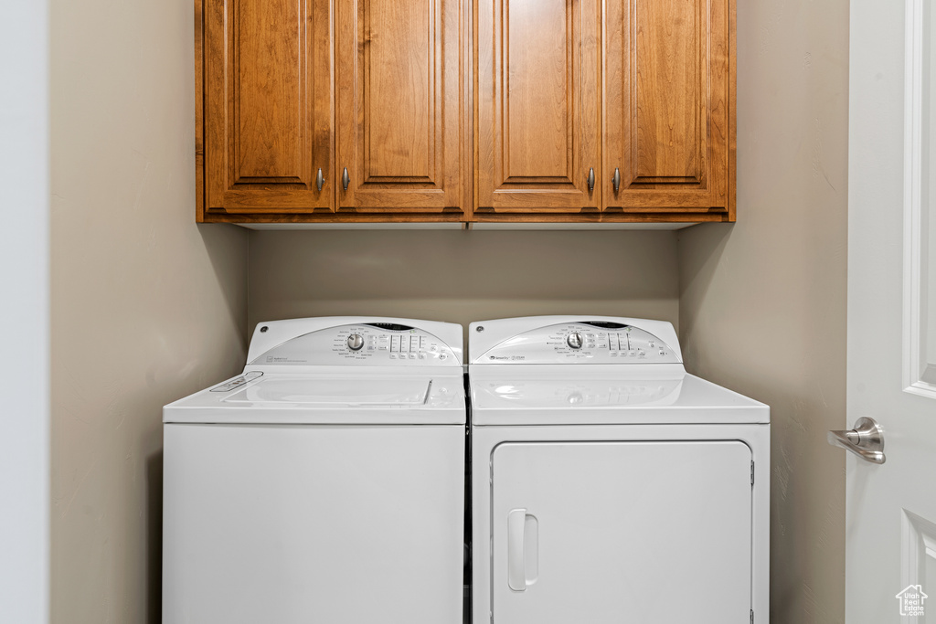 Washroom with cabinet space and independent washer and dryer