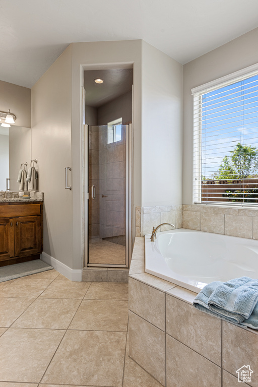 Bathroom with a healthy amount of sunlight, a garden tub, and tile patterned floors