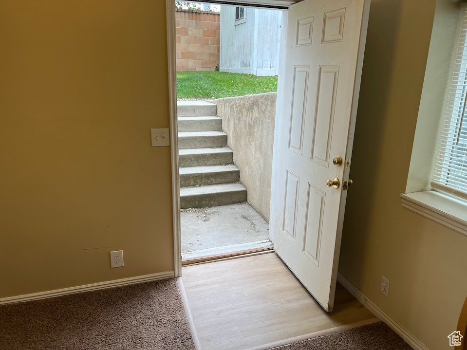 Entryway featuring stairs, carpet, and baseboards