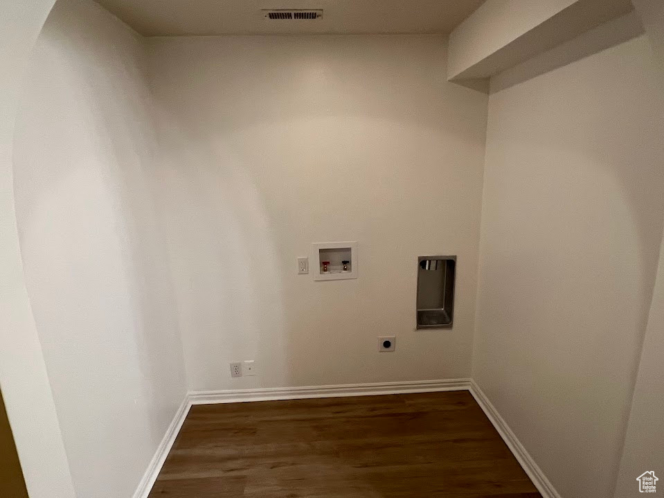 Clothes washing area featuring dark wood finished floors, visible vents, washer hookup, hookup for an electric dryer, and laundry area