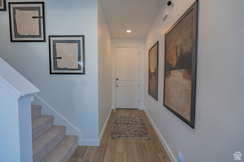 Hallway with stairs, recessed lighting, wood finished floors, and baseboards