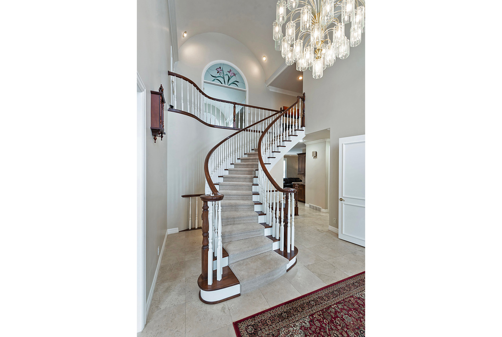 Staircase with a high ceiling, tile patterned floors, and baseboards