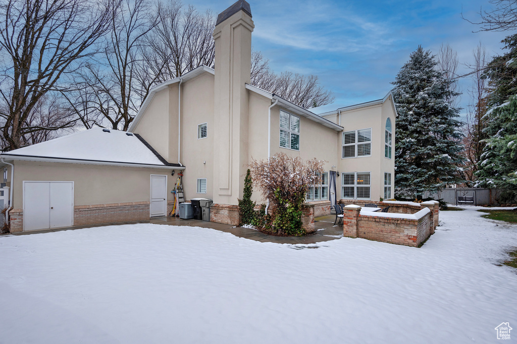 Exterior space featuring brick siding, a chimney, and stucco siding