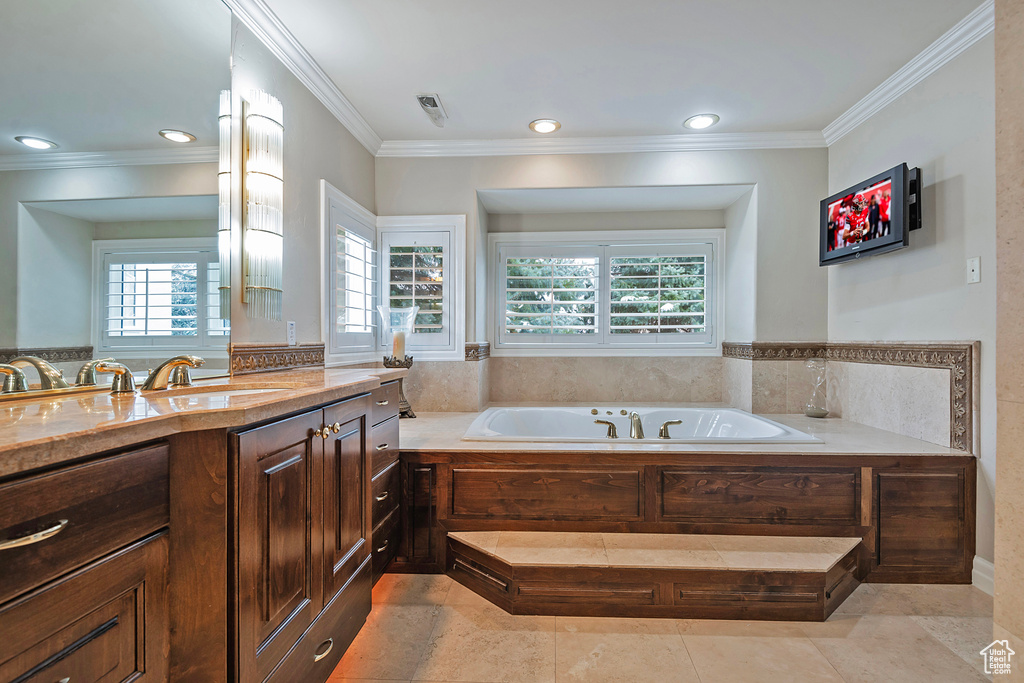 Bathroom featuring recessed lighting, vanity, a bath, and crown molding