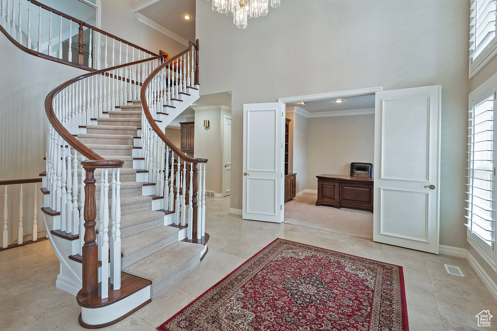 Entrance foyer featuring a wealth of natural light, baseboards, visible vents, and a high ceiling